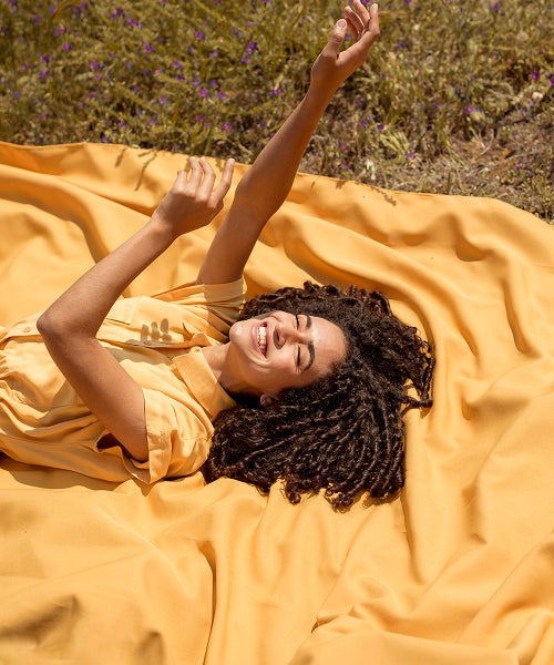 Woman laughing outdoors on a sunny afternoon